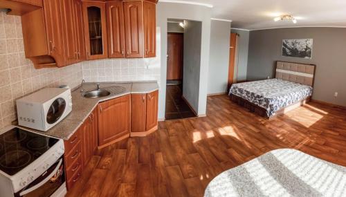 una cucina con armadi in legno e un letto in una camera di Apartamienty na Profsoiuznoi a Tyumen