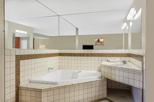 a bathroom with a tub and a sink at Travelodge by Wyndham Reno in Reno