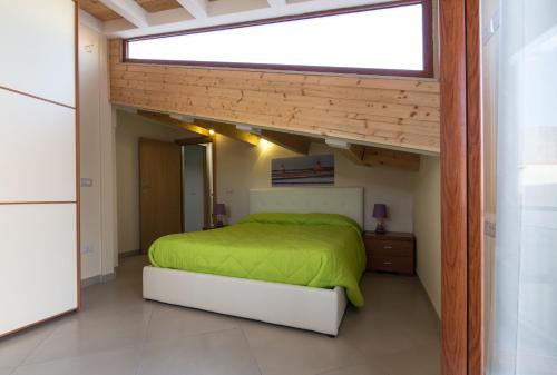 メッシーナにあるCase Panoramiche sul Lagoのベッドルーム(緑のベッド1台、窓付)