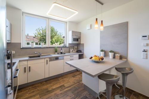 a kitchen with a large island with a bowl of fruit on it at MA-LIVING Miralior Apartment Mainz in Mainz