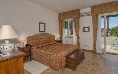 Hotel Verdemare في مارينا دي بيتراسانتا: غرفة نوم بسرير وطاولة مع مصباح