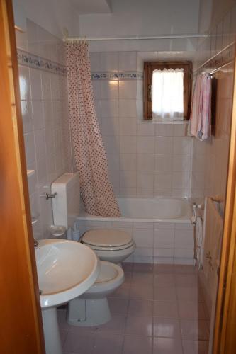 a bathroom with two toilets and a tub and a sink at Appartamento Polino in Chianciano Terme