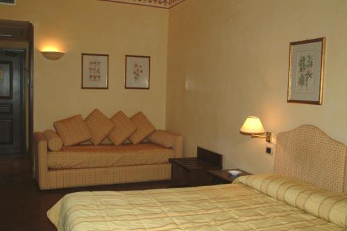 a hotel room with a bed and a couch at Hotel La Ville in Catania