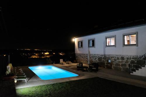 a swimming pool in front of a house at night at Quinta de Vodra in Seia