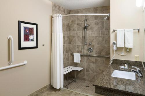 a bathroom with a shower and a sink at Aspen Suites - Rochester in Rochester