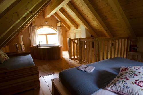 ein Schlafzimmer mit einem Bett und einer Badewanne in einer Hütte in der Unterkunft Alpi Giulie Chalets in Valbruna
