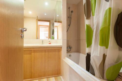 a bathroom with a sink and a shower curtain at Apartamento Expo in Lisbon
