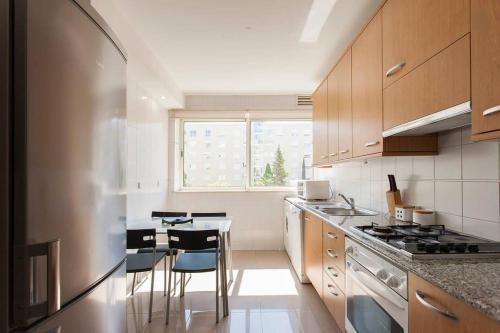 a kitchen with a table and some chairs in it at Apartamento Expo in Lisbon