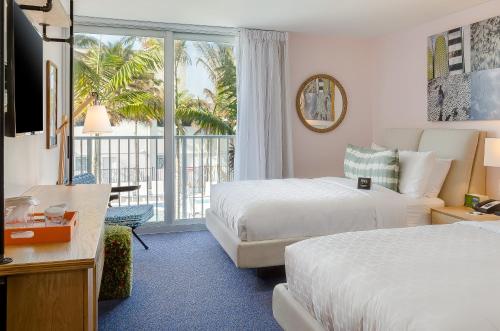 a hotel room with two beds and a balcony at Plunge Beach Resort in Fort Lauderdale