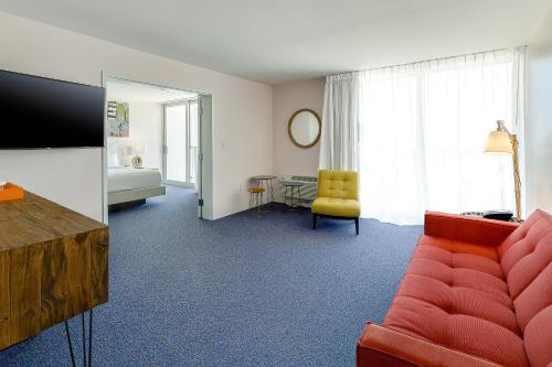 a living room with a red couch and a yellow chair at Plunge Beach Resort in Fort Lauderdale