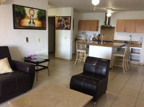 a living room with a couch and a kitchen at Suites Atlas - Ocean Front in Bucerías