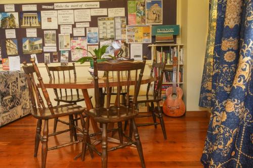 a table with chairs and a table with a plant at Empire Hotel Backpackers in Oamaru
