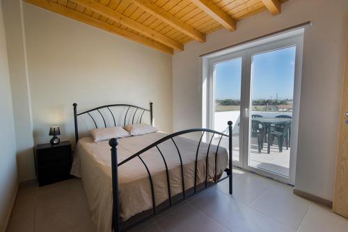 sypialnia z łóżkiem oraz balkon ze stołem w obiekcie Cavaleiro Rota Costa Alentejana w mieście Cavaleiro