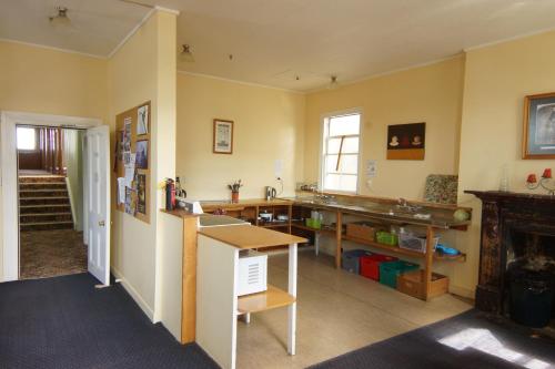 uma cozinha com um balcão e uma mesa num quarto em Empire Hotel Backpackers em Oamaru