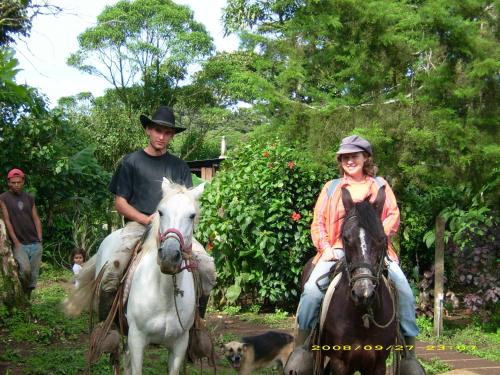 mężczyzna i kobieta jeżdżący na koniach z psem w obiekcie Finca Lindos Ojos w mieście Estelí