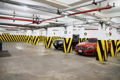 a parking garage with two cars parked in it at Hotel Las Lomas in Lima