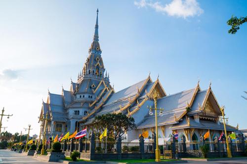 a large white building with a tower on a street at Kesorn Boutique Residence at 8 Riew in Chachoengsao