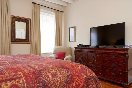 a bedroom with a bed and a television at Cheltenham Suites in Caledon