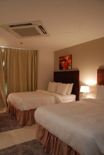 a hotel room with two beds and a window at Ramada by Wyndham Princess Paramaribo in Paramaribo