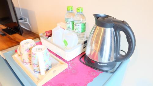 a kitchen counter with a tea kettle and milk bottles at Kesorn Boutique Residence at 8 Riew in Chachoengsao