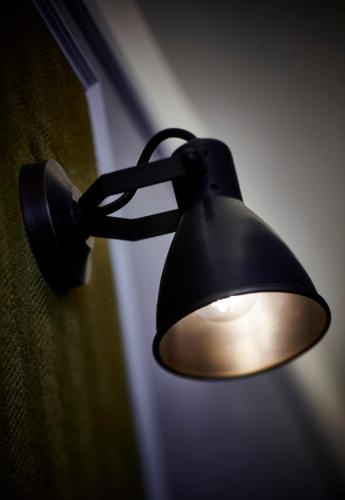 a black lamp hanging on the side of a wall at Little Tai Hang in Hong Kong