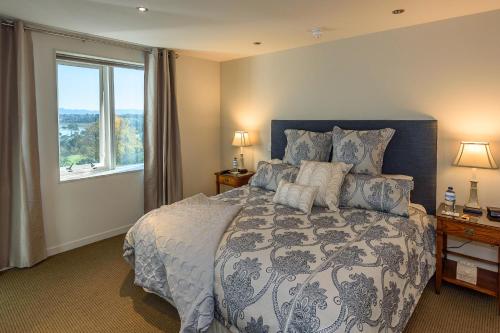 a bedroom with a large bed with a large window at Top Of The Town Bed & Breakfast in Tauranga