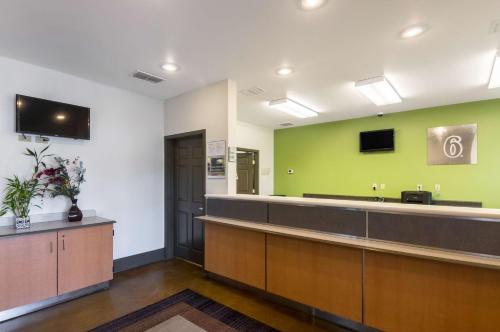 a waiting room with a green wall at Studio 6-Lubbock, TX - Medical Center in Lubbock