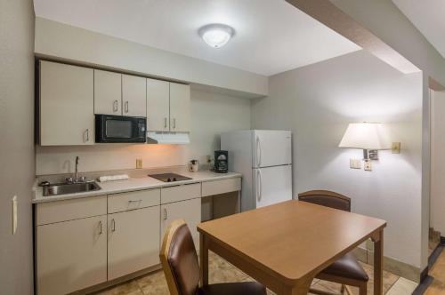 a small kitchen with a table and a refrigerator at Studio 6-Lubbock, TX - Medical Center in Lubbock
