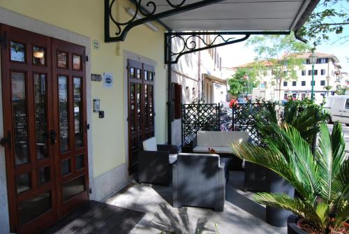 an outdoor patio with doors and chairs and plants at Hotel Alla città di Trieste in Grado