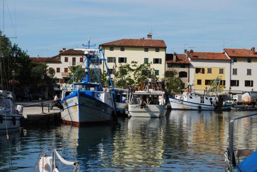 a group of boats docked in a harbor with buildings at Hotel Alla città di Trieste in Grado