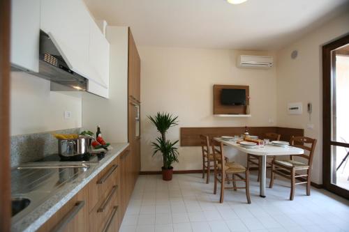 a kitchen and dining room with a table and chairs at The Garda Village in Sirmione