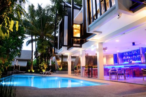 a house with a swimming pool in front of a building at Deevana Krabi Resort in Ao Nang Beach