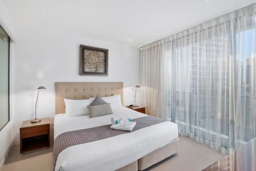 a bedroom with a bed and a large window at Oracle Resort Broadbeach - gclr in Gold Coast