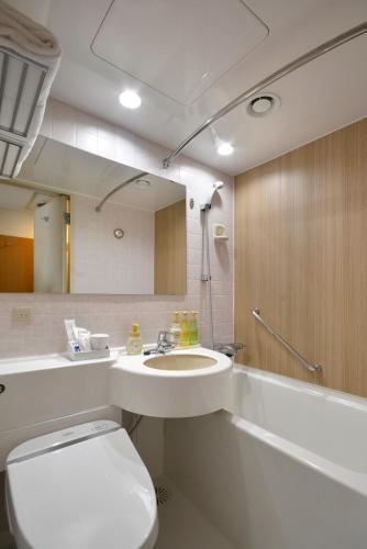 a bathroom with a toilet and a sink and a tub at Premier Hotel Cabin Shinjuku in Tokyo