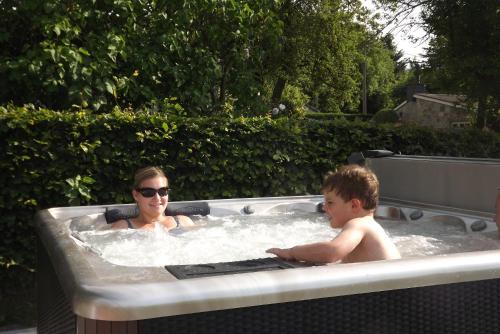 a woman and a child in a hot tub at B&B La Buissonniere in Xhoris