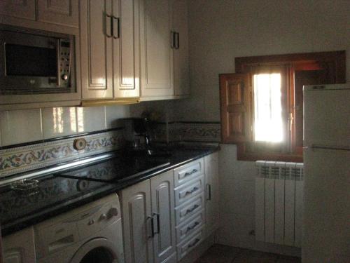 a kitchen with white cabinets and a white refrigerator at Casa Marzo in Angüés