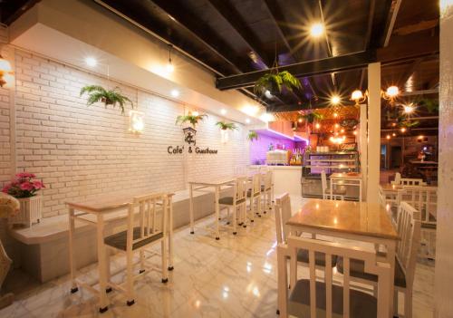 a restaurant with tables and chairs and a brick wall at The history cafe' & guesthouse in Sukhothai
