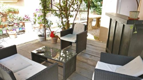 a patio with wicker chairs and a glass table at La Chicca B&B Siena in Siena