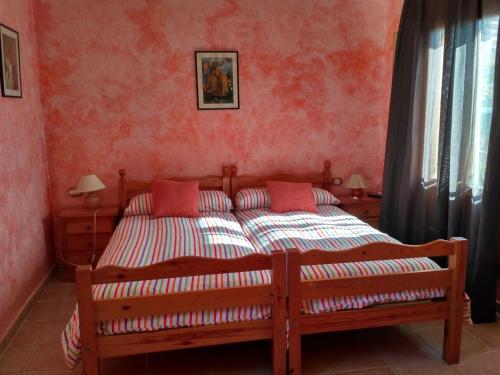 a bedroom with a large bed with red walls at Casa Marzo in Angüés