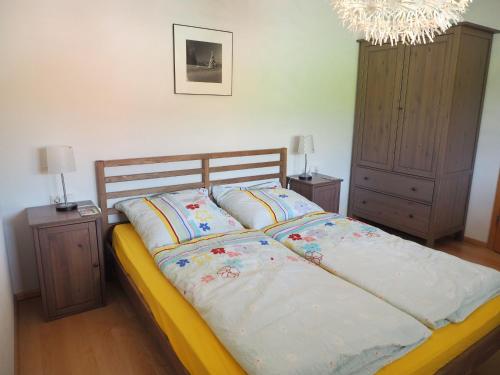 a bedroom with a bed and two night stands and a chandelier at Ferienwohnung Bergahorn in Todtnauberg