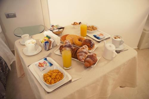 a breakfast table with breakfast foods and orange juice at San Pietro Grand Suite in Rome