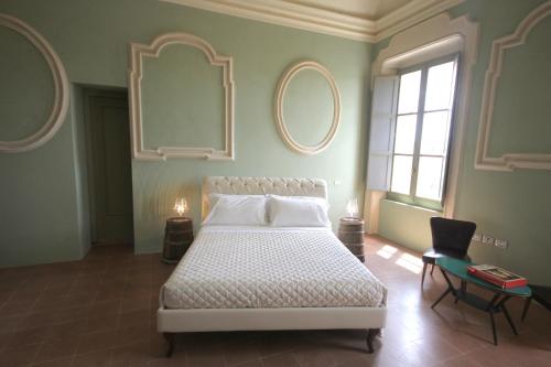 a bedroom with a bed and two mirrors on the wall at Antico Convento San Francesco in Bagnacavallo
