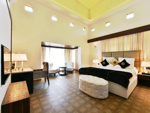 a bedroom with a large bed and a living room at Della Resorts in Lonavala