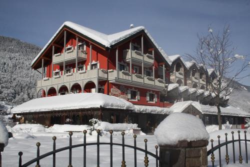 a large red building with snow on top of it at Hotel La Bussola in Andalo
