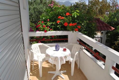 a table and chairs on a balcony with flowers at Stergia Apartments in Kardamaina