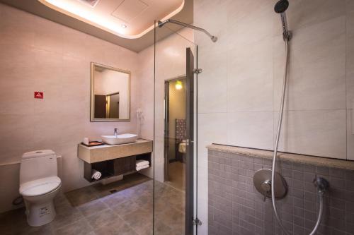 a bathroom with a shower and a toilet and a sink at Esun Villa Hotel in Chiayi City