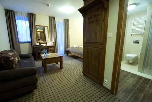 a living room with a couch and a bed in a room at Hotel Biathlon Sport & Spa in Szklarska Poręba