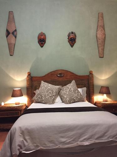 a bedroom with a bed with masks on the wall at Baobab Lane Lodge in Marnitz