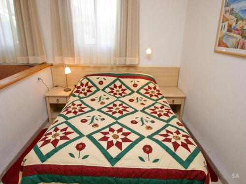 a bedroom with a bed with a quilt on it at Bagoren in Metulla