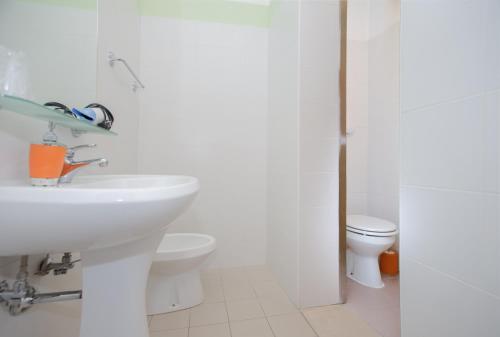 a white bathroom with a sink and a toilet at Hotel Il Lato Azzurro - Isola di Sant'Erasmo - NO VEHICLES ACCESS in Venice